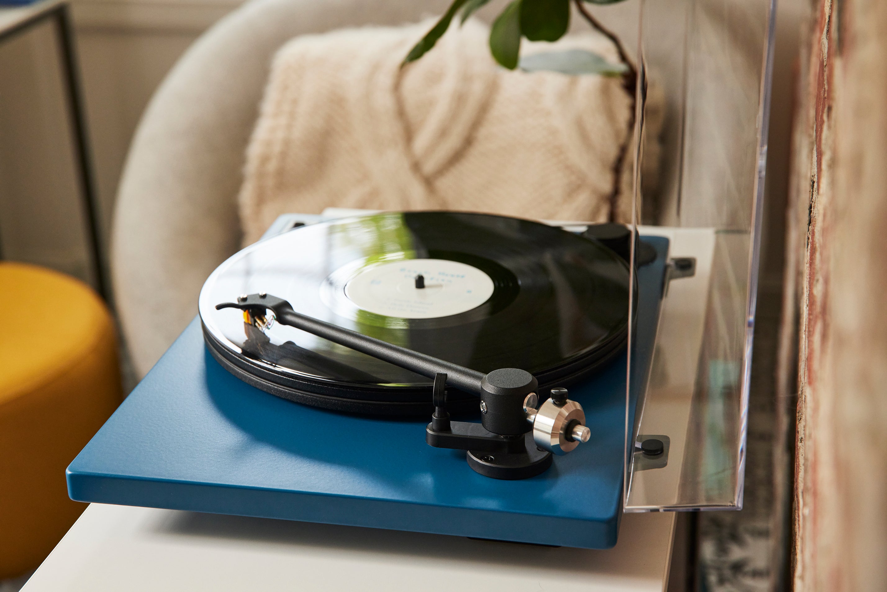 blue turntable with tonearm on record