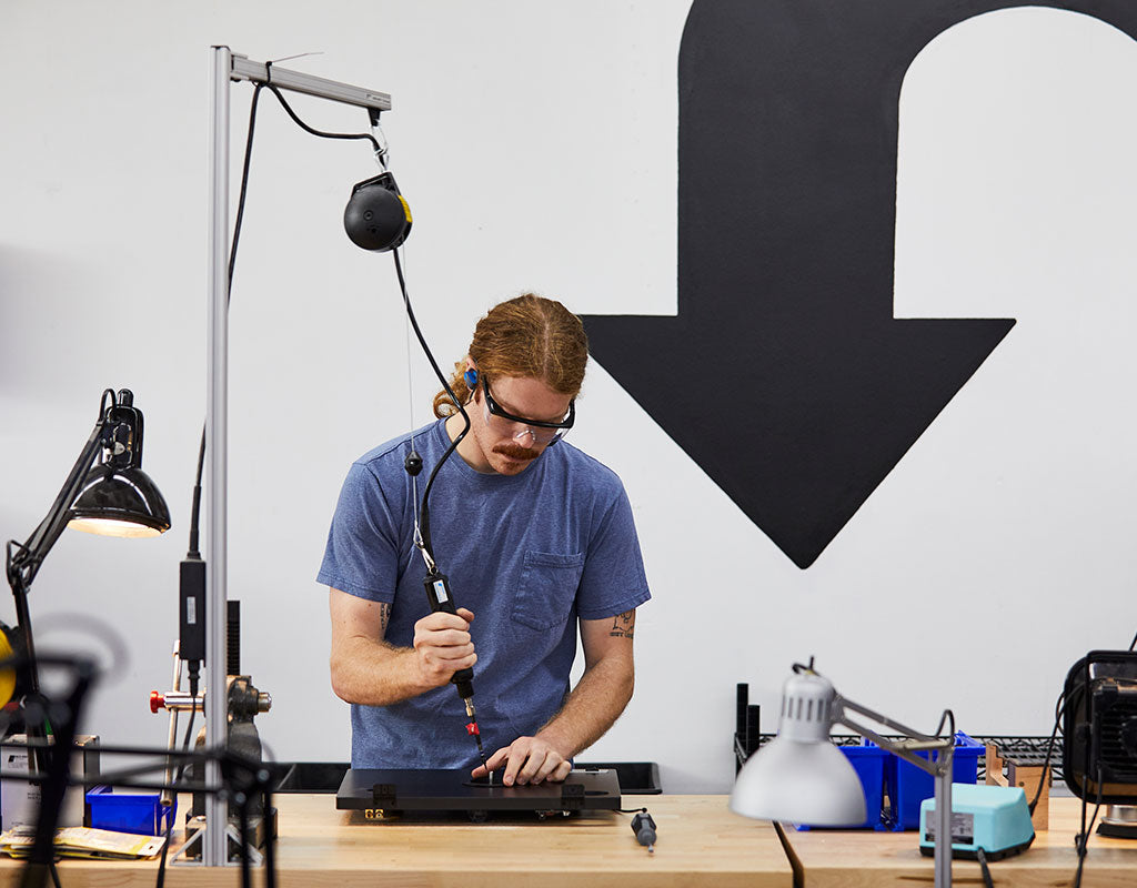 Assembly technician assembling a product at the U-Turn Audio manufacturing facility